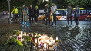 epa06150592 People place candles and flowers to the site where one person was stabbed to death on the Market Square in Turku, Finland, 18 August 2017. According to police reports on 18 August, two people were killed and six people injured in a stabbing spree on two market squares in the city. Finnish police shot at and apparently injured the stabber and were reported to search for possible other perpetrators.  EPA/MARKKU OJALA